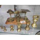 A set of brass postal scales with weights and another set of brass weights.
