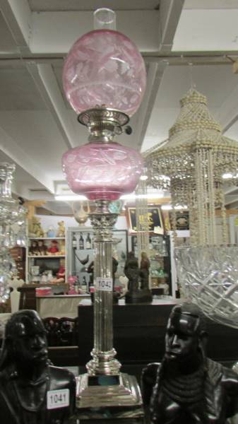 A silver plated Corinthian column oil lamp with pink glass font and shade. Collect only.