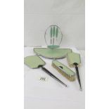 An art deco dressing table set comprising tray with manicure items. hand mirror and two brushes.