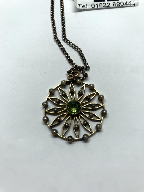 A 15ct gold pendant set peridot and seed pearls on a 9ct gold chain. - Image 6 of 7