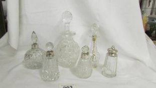 Three scent bottles with silver collars, a pepper pot with silver top and two other silver collars.