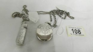 A white metal locket on chain and a silver needlecase of white metal chain.