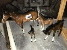 A Beswick horse, foal and two other horses
