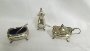 A three piece silver condiment set.