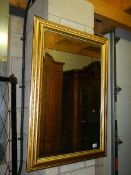 A bevel edged gilt framed mirror, 69 x 100 cm.