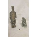 A carved stone figure of a terracotta soldier and a carved soapstone lizard.