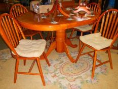 An oval extending dining table with five chairs. (Collect only).