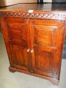 A two door oak record cabinet with panelled doors. (Collect only).