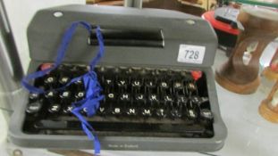 A portable typewriter (needs attention).