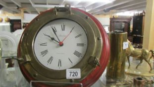 A brass clock in the form of a ship's porthole.