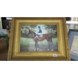 A gilt framed print of a racehorse.