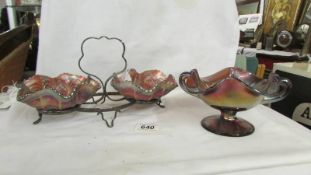 Two carnival glass bowls on a plated stand and one other dish.