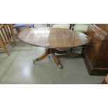 An oval coffee table with glass top on brass lion paw casters.