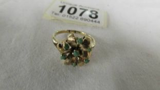 A textured gold ring dated 1967 set hardstones in flower design.