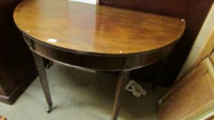 A mahogany D shaped table.