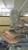Two wooden wall masks and another wooden item.