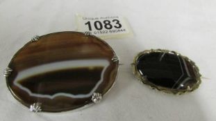 Two Victorian banded agate brooches, one in yellow metal, one in white metal.