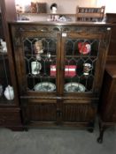 A dark oak priory style display cabinet with cupboard base & leaded glass doors (95cm x 32cm x