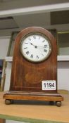 A mahogany inlaid mantel clock.