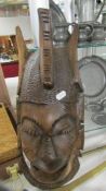 A carved wood wall mask.