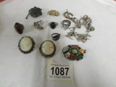 A mixed lot including charm bracelet with some silver charms, 2 cameo brooches, 2 silver rings etc.,