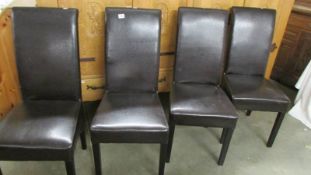 A set of four black dining chairs.