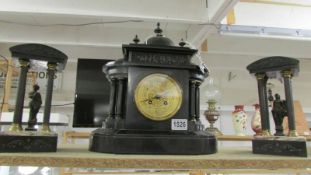 A Victorian black marble mantel clock with two Grecian style side pieces.