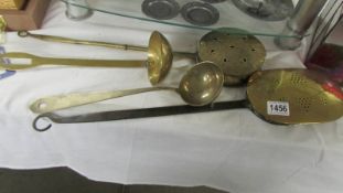 Two brass chestnut roasters and two brass ladles.