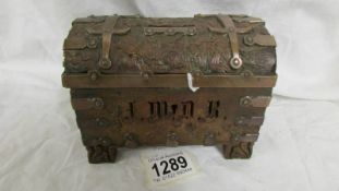 An carved wooden money box with metal mounts in the arts crafts style, dated London 1936.