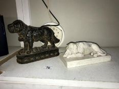 A cast iron door stop of a St Bernard and a plaster laying down dog
