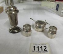 A silver three piece condiment set and a silver pepperette.