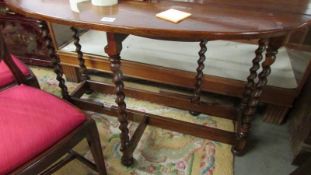 An oval oak barley twist gate leg table.