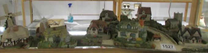 Ten model cottages including Royal Doulton and a cottage base.