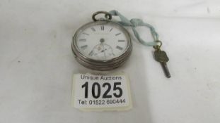 A Kendal and Dent silver pocket watch with key, in working order.