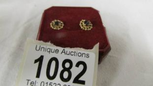 A pair of garnet set 9ct gold earrings.