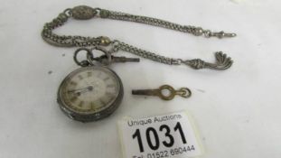 A Victorian ladies silver fob watch with ornate white metal chain.
