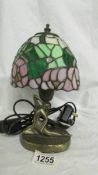 An art deco style white metal table lamp with leaded glass shade.