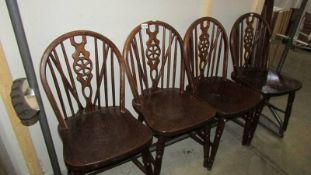 A set of four wheel back chairs.