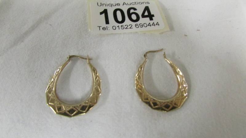 A pair of 9ct gold textured hoop earrings.