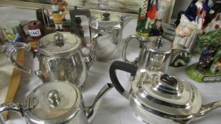 Five silver plate teapots.