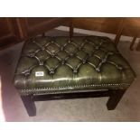 A deep buttoned green leather foot stool