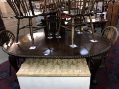 A Victorian mahogany oval wind-out dining table with carved rope edges and Claw and Ball castered