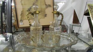 A gold decorated glass tray, two claret jugs and three glasses.