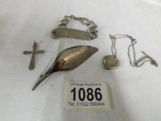 A silver identity bracelet, a silver brooch, a silver cross and a silver locket on chain.