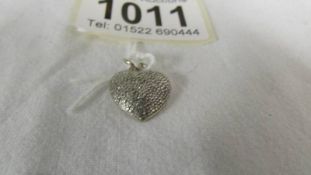 A white gold and diamond heart pendant, (missing one stone).