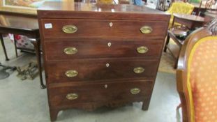 A four drawer mahogany desk with string inlay and brass handles.