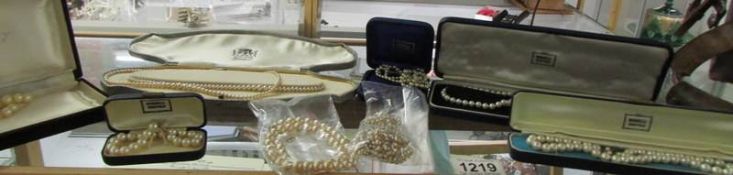 A small vintage vanity case containing various pearls with gold and silver clasps.