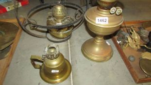 A hanging oil lamp and two other oil lamps.