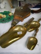 Three brass scoops and a set of bellows.