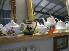 Four collectable teapots and a Totnes jug.